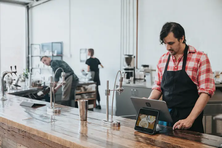 A barista billing on a tablet
